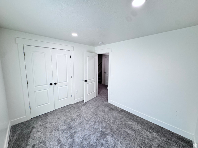 4729 Middleboro Road Herriman, UT 84096 - Photo 18 of 19 Room featuring white walls, gray textured carpeting, and recessed lighting