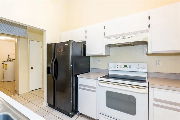 a kitchen with granite countertop a refrigerator and a sink