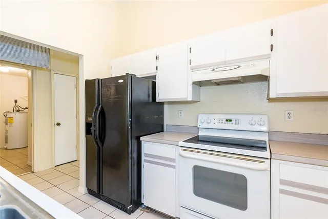 a kitchen with granite countertop a refrigerator and a sink