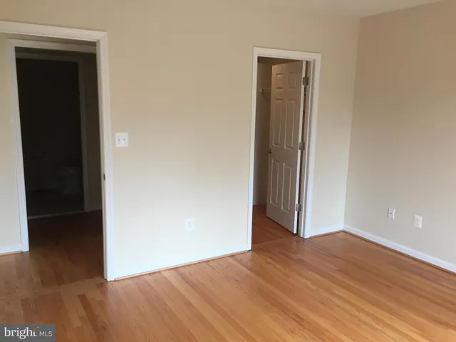 an empty room with wooden floor and closet
