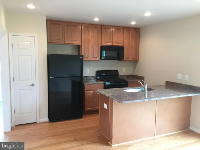 a kitchen with stainless steel appliances granite countertop a refrigerator a stove a microwave and a sink