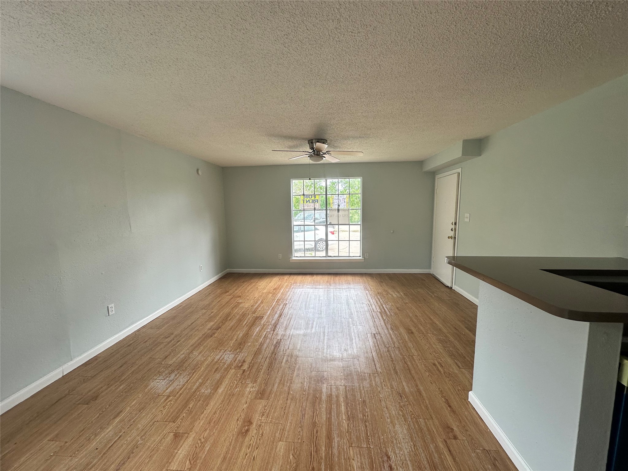 607 Reed Avenue Wharton, TX 77488 - Photo 2 of 13 an empty room with wooden floor and windows