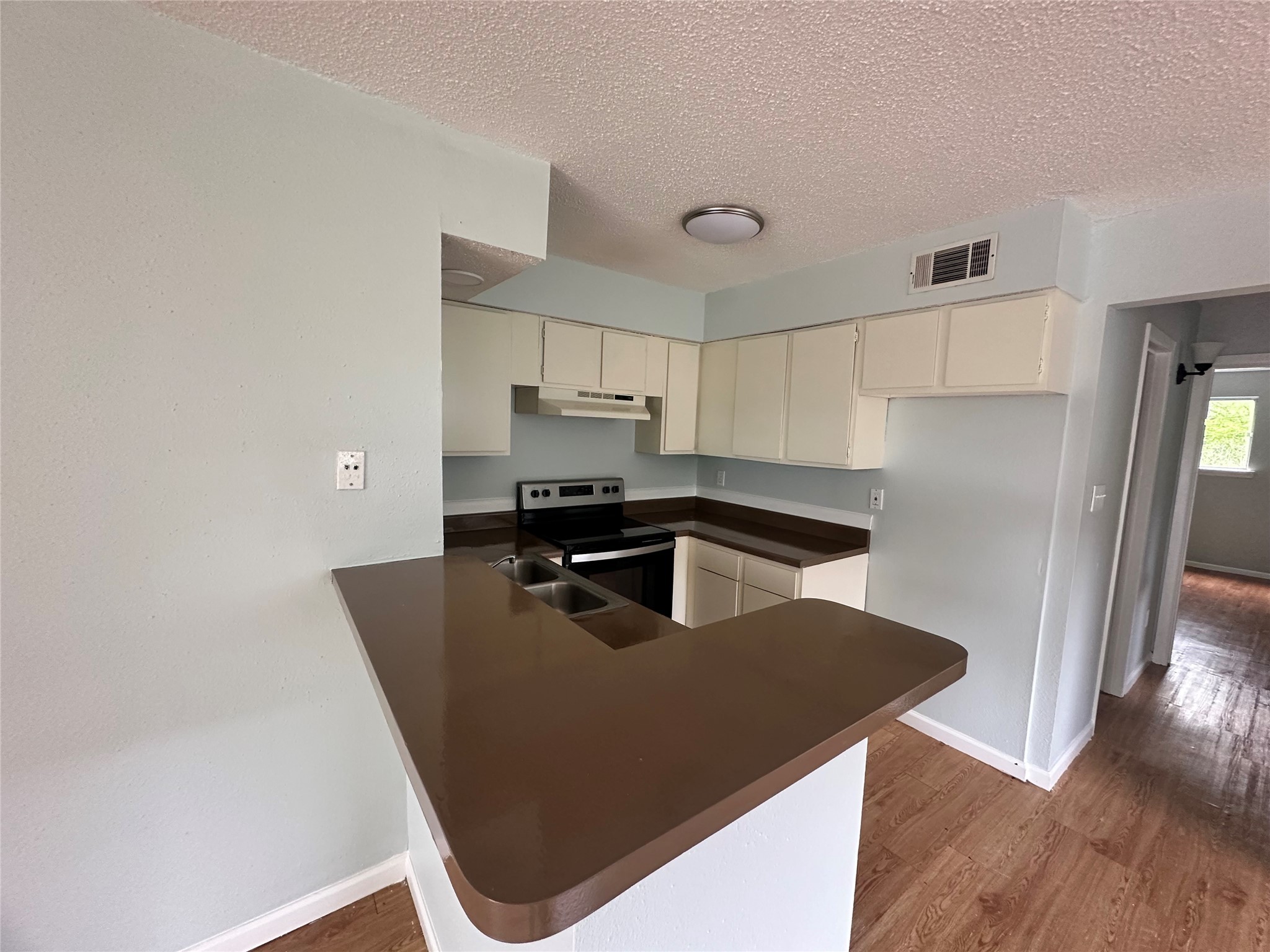 607 Reed Avenue Wharton, TX 77488 - Photo 4 of 13 a kitchen with kitchen island a counter top space a sink a refrigerator and cabinets