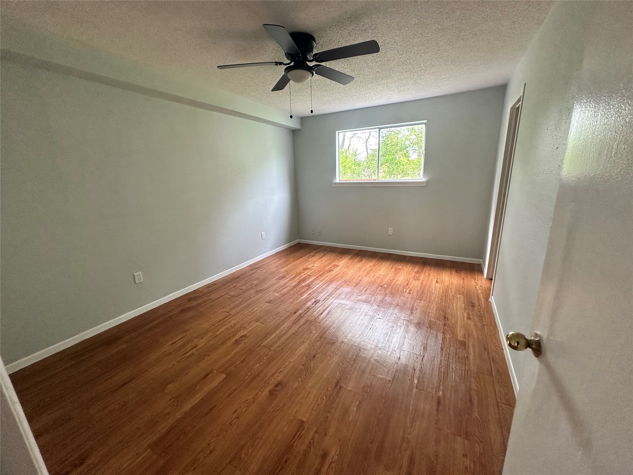 607 Reed Avenue Wharton, TX 77488 - Photo 8 of 13 an empty room with wooden floor fan and windows