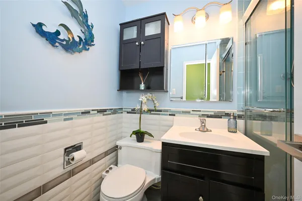 a bathroom with a sink vanity mirror and toilet