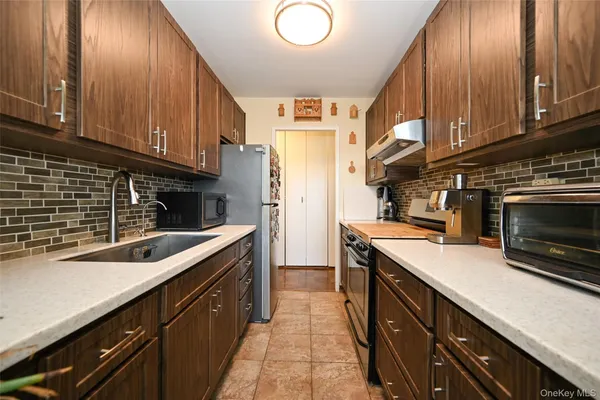 a kitchen with stainless steel appliances granite countertop a sink a stove and cabinets