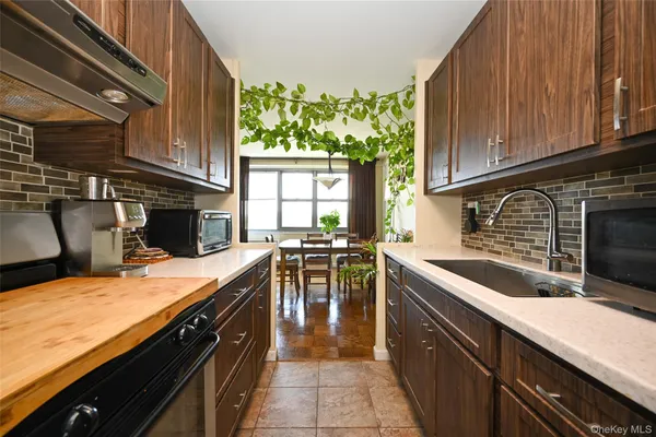 a kitchen with stainless steel appliances granite countertop sink stove top oven and cabinets