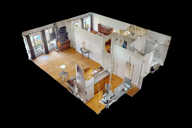 a view of an empty room with a window and a kitchen