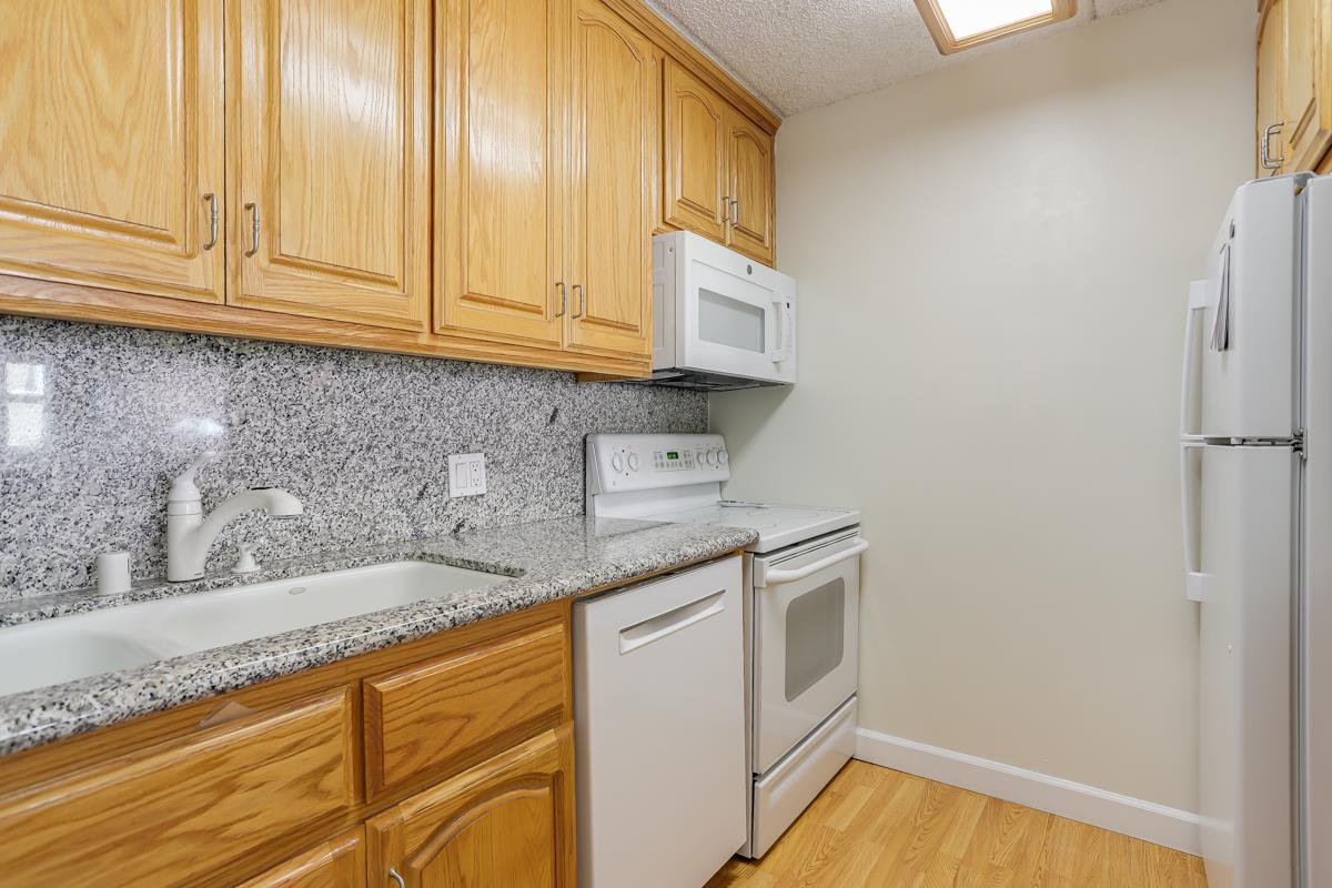 1700 Civic Center Drive, Unit 214 Santa Clara, CA 95050 - Photo 7 of 17 a kitchen with stainless steel appliances granite countertop a sink and dishwasher with white cabinets