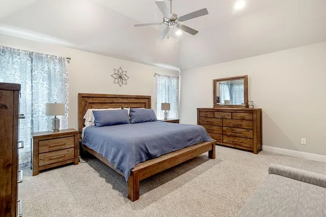 a spacious bedroom with a bed lamp and a chandelier