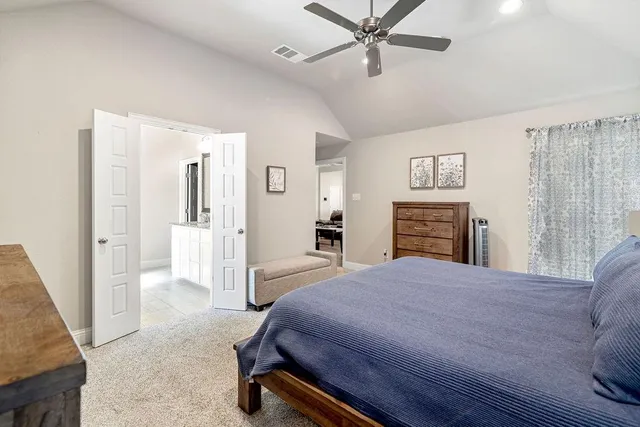 a spacious bedroom with a bed and a dresser