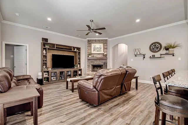 a living room with furniture a flat screen tv and kitchen view