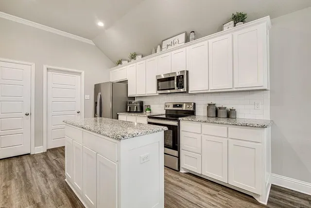 a kitchen with stainless steel appliances granite countertop a sink and dishwasher a stove top oven with wooden floor