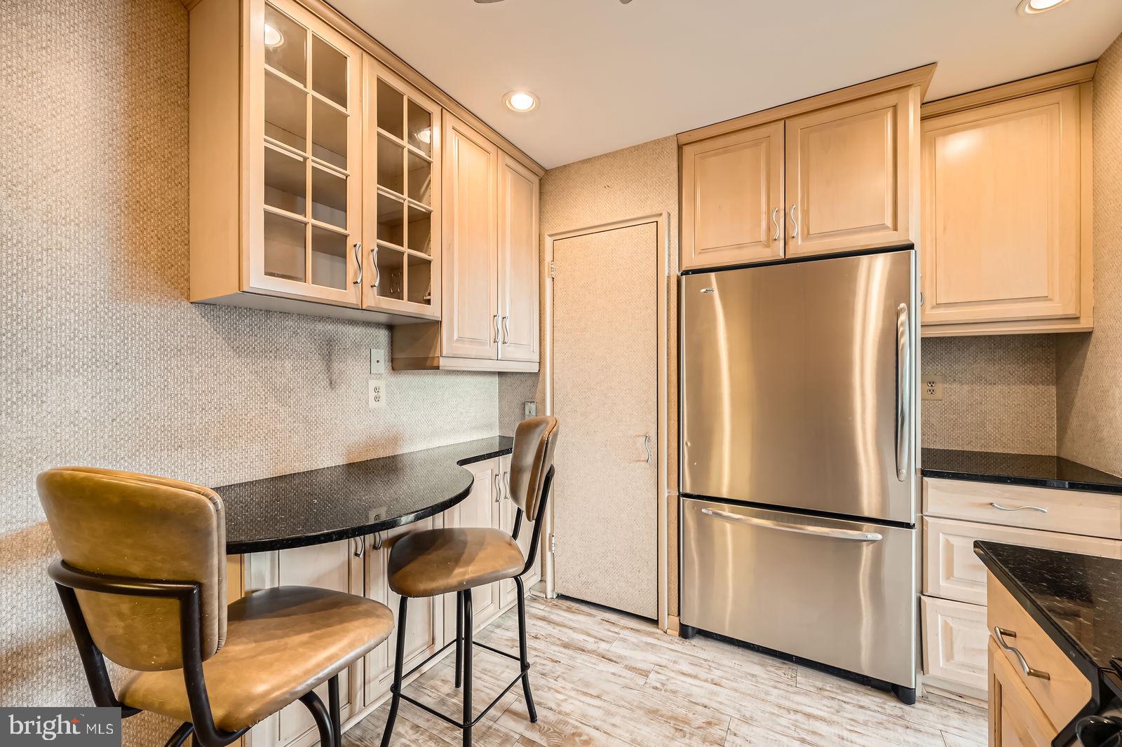 11 Slade Avenue, Unit 509 Baltimore, MD 21208 - Photo 11 of 30 a kitchen with stainless steel appliances granite countertop a refrigerator a dining table and chairs