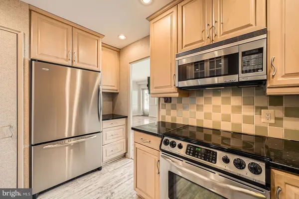 a kitchen with stainless steel appliances granite countertop a refrigerator stove and microwave