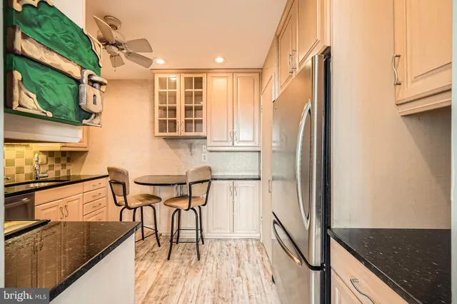 a kitchen with stainless steel appliances granite countertop a refrigerator and a stove top oven