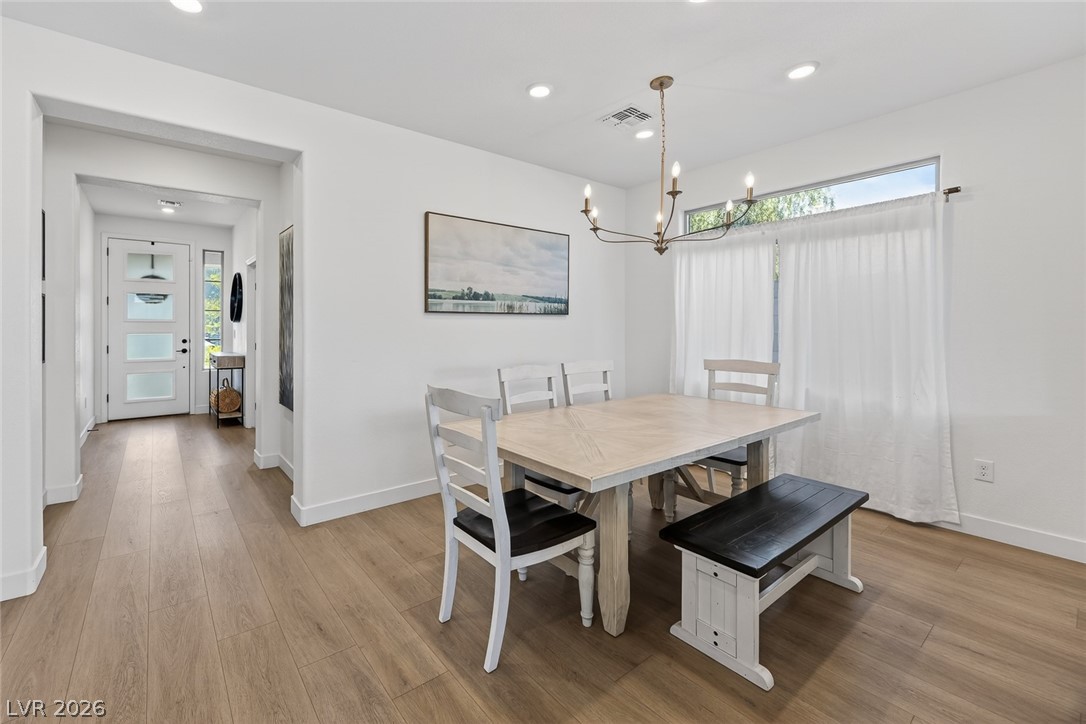 10446 Emerald Rye Street Las Vegas, NV 89183 - Photo 6 of 37 Illuminated by natural light and a chic chandelier, this dining area sets a pleasant stage for everyday meals.