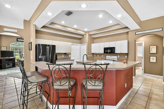 a kitchen with stainless steel appliances granite countertop a stove refrigerator sink and microwave