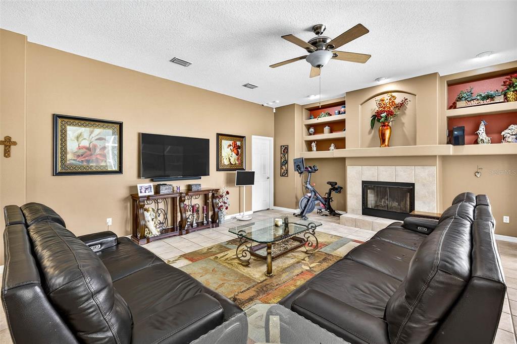 8518 West Knights Griffin Road Plant City, FL 33565 - Photo 21 of 74 a living room with furniture a flat screen tv and a fireplace