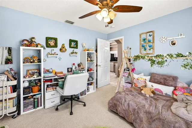 a bedroom with a bed a mirror on dresser and a chandelier