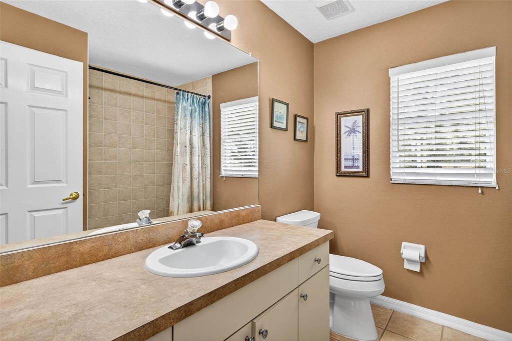 8518 West Knights Griffin Road Plant City, FL 33565 - Photo 28 of 74 a bathroom with a granite countertop sink toilet and mirror