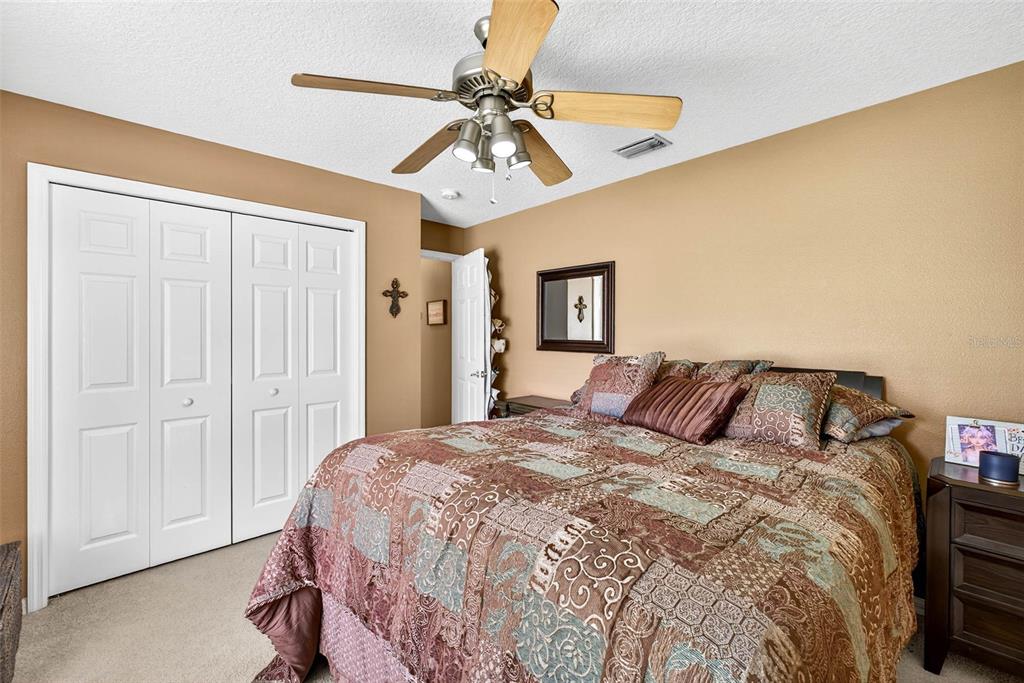 8518 West Knights Griffin Road Plant City, FL 33565 - Photo 31 of 74 a bedroom with a bed and a chandelier