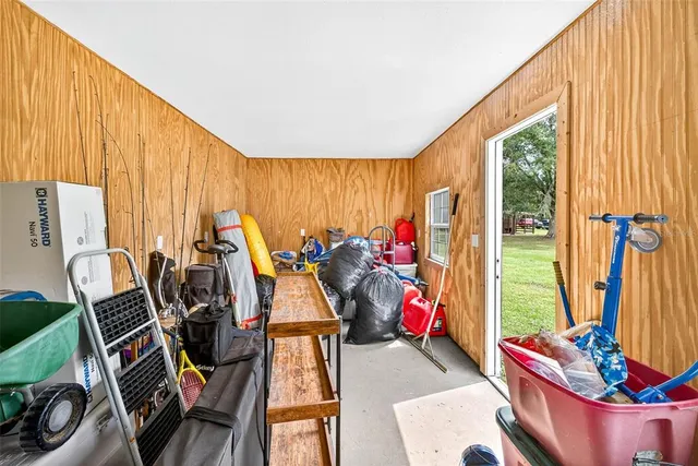 an aerial view of a residential houses with outdoor space and trees