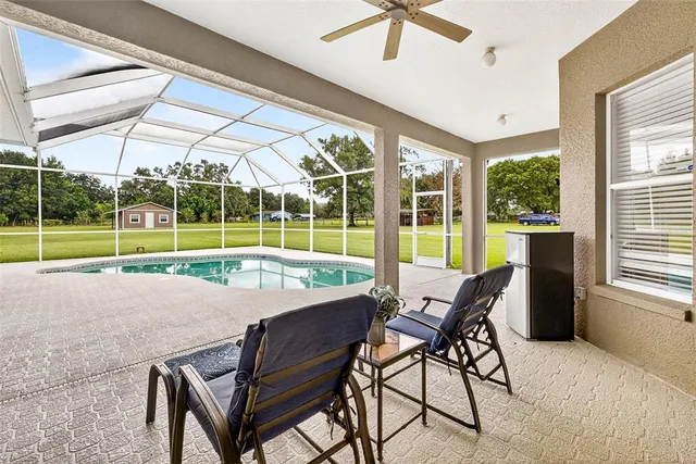 an aerial view of a residential houses with outdoor space and trees