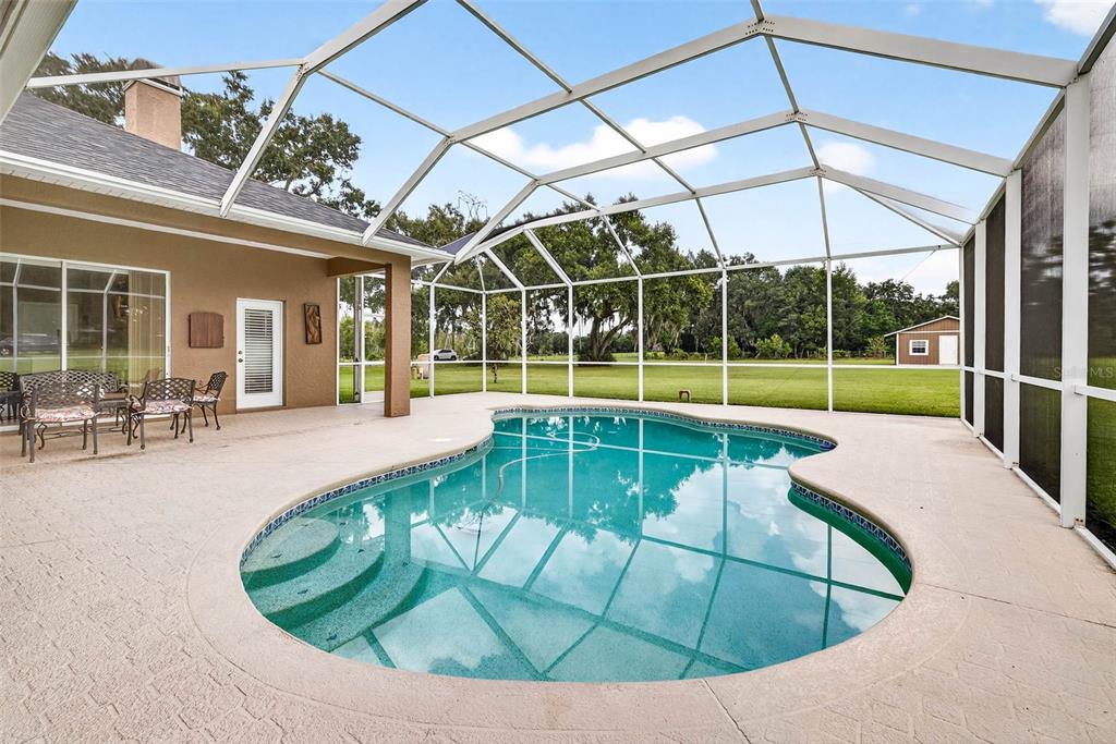 8518 West Knights Griffin Road Plant City, FL 33565 - Photo 51 of 74 a view of a swimming pool with an outdoor seating