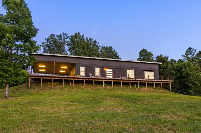 a kitchen with stainless steel appliances a sink a stove a refrigerator cabinets and a dining table