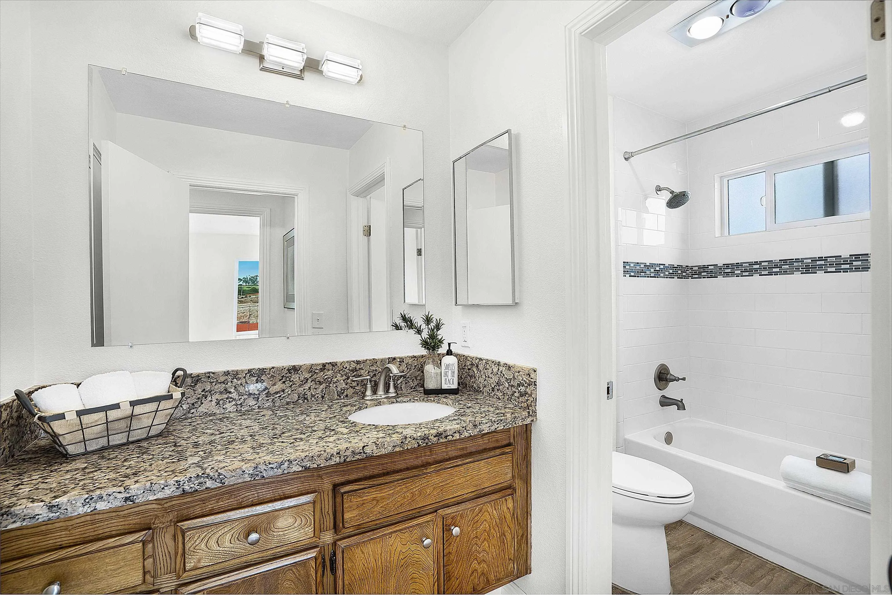 1138 Sidonia Street Encinitas, CA 92024 - Photo 15 of 17 a bathroom with a granite countertop sink a toilet a mirror and shower