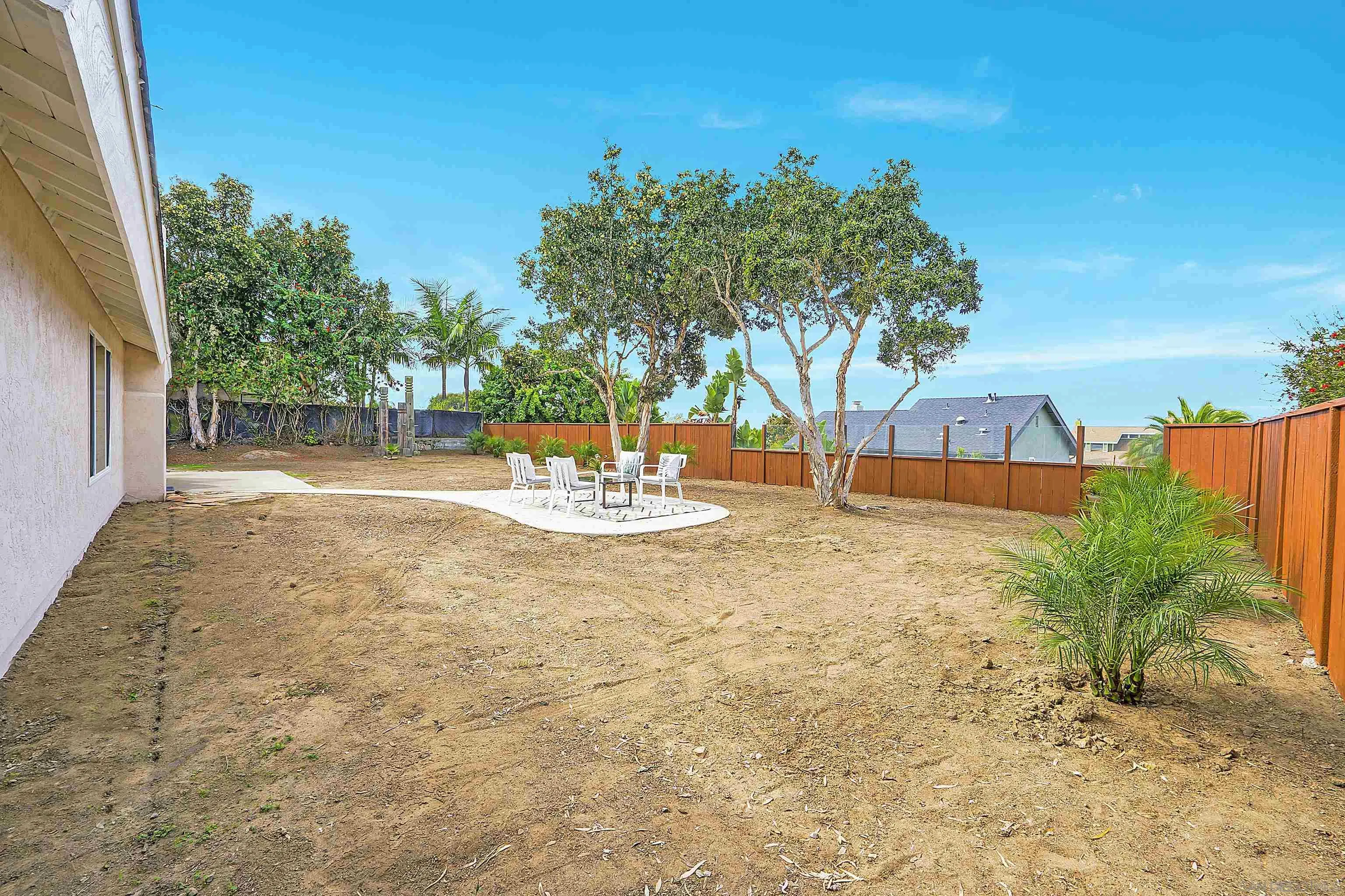 1138 Sidonia Street Encinitas, CA 92024 - Photo 16 of 17 a backyard of a house with table and chairs under an umbrella