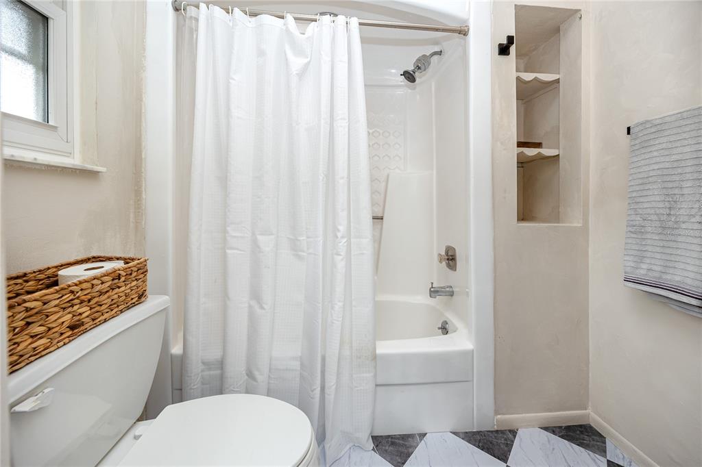 27 Summit Lane Safety Harbor, FL 34695 - Photo 18 of 48 a bathroom with a toilet and a shower curtain