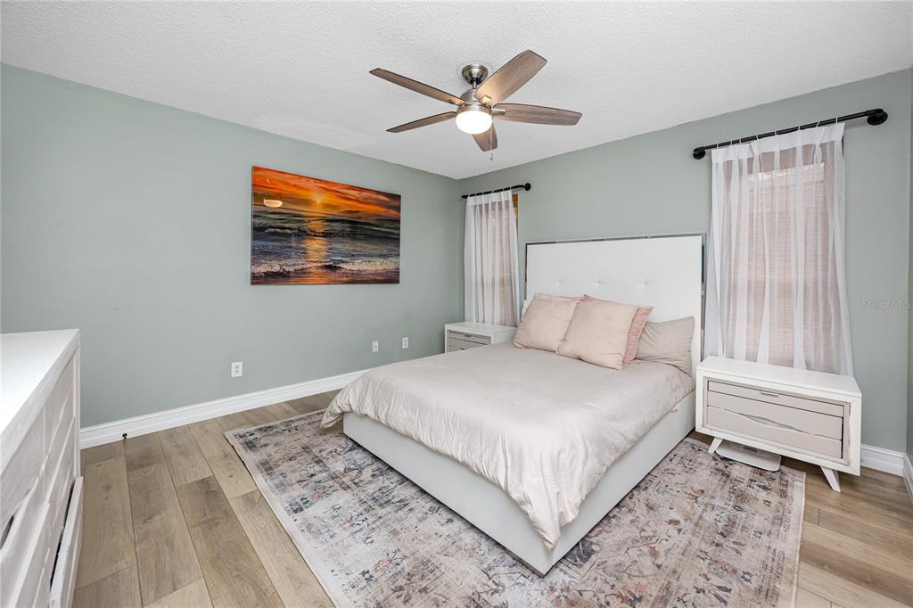 27 Summit Lane Safety Harbor, FL 34695 - Photo 19 of 48 a bedroom with a large bed and a ceiling fan