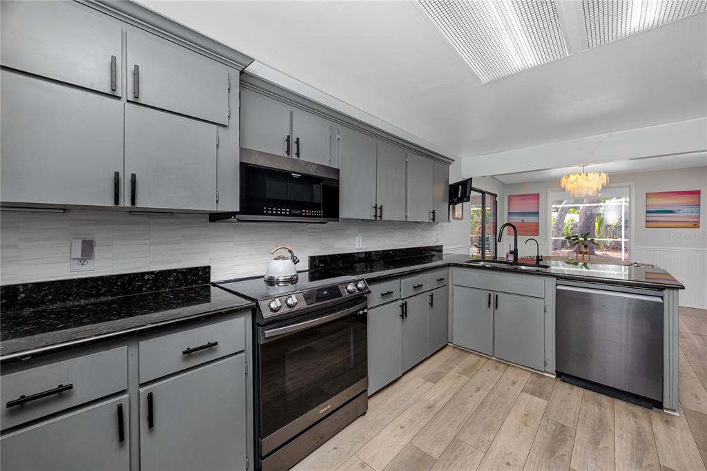 27 Summit Lane Safety Harbor, FL 34695 - Photo 7 of 48 a kitchen with stainless steel appliances granite countertop a stove a sink and a microwave