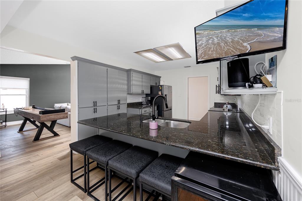 27 Summit Lane Safety Harbor, FL 34695 - Photo 9 of 48 a kitchen with kitchen island granite countertop a table chairs stove and granite counter tops