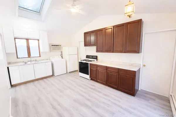 a kitchen with stainless steel appliances granite countertop a dishwasher a stove a refrigerator with white cabinets and wooden floor