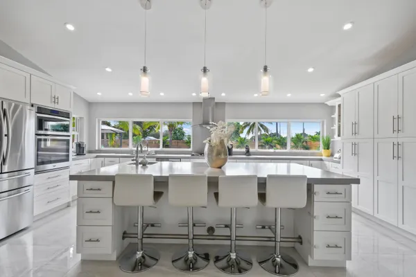 a kitchen with kitchen island granite countertop a sink and cabinets