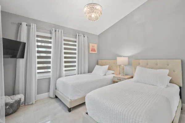 a bedroom with a bed and a chandelier