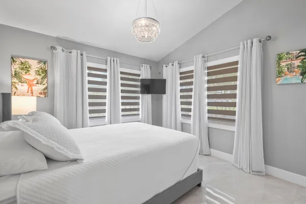 a bedroom with a bed and a chandelier