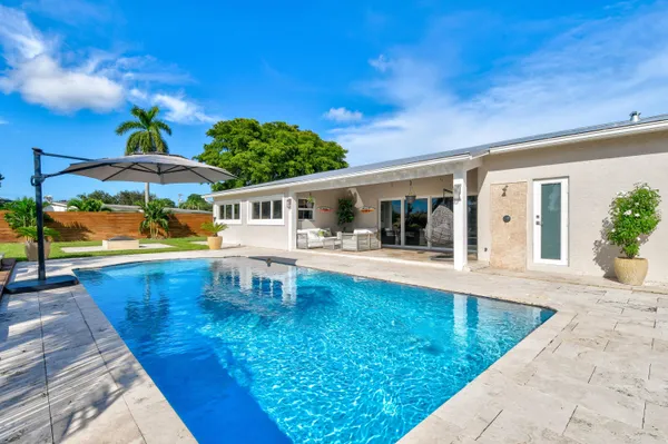 swimming pool view with a seating space and a garden view