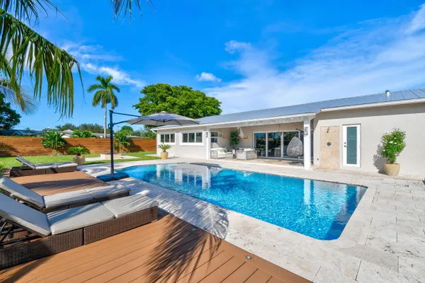 a view of a house with swimming pool and sitting area