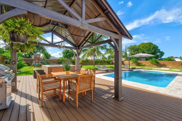a view of a patio with table and chairs with wooden floor and fence
