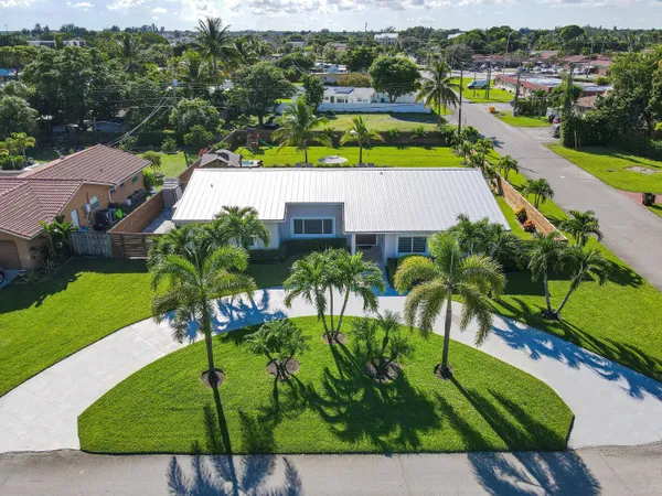 an aerial view of a house with a garden and lake view