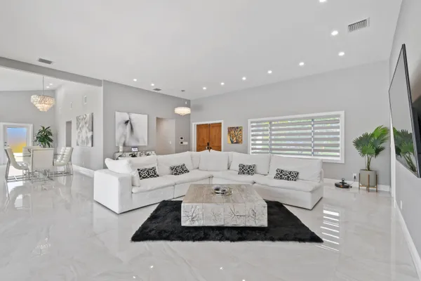 a living room with furniture large window and wooden floor