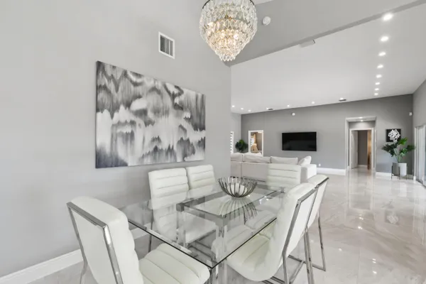 a view of a dining room with furniture and a chandelier