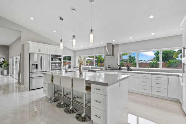 a kitchen with stainless steel appliances kitchen island granite countertop a table and chairs in it