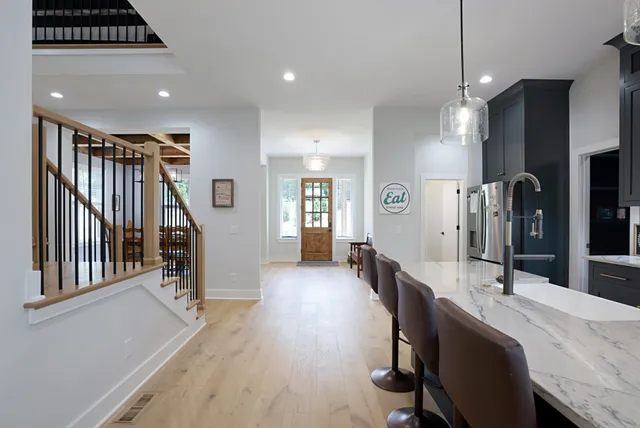 a dining hall with stainless steel appliances granite countertop a stove a sink dishwasher and a refrigerator with wooden floor