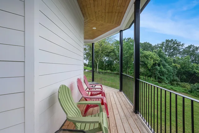 a view of a balcony with wooden floor and fence