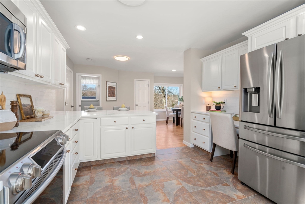 12 Silvermine Road Woburn, MA 01801 - Photo 12 of 36 a kitchen with white cabinets and stainless steel appliances